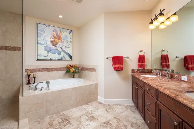 a bathroom with a tub a sink and a mirror