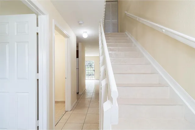 a view of staircase with white walls and windows