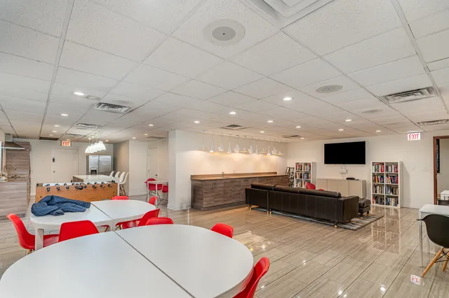 a living room with kitchen furniture and a flat screen tv