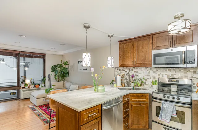 a kitchen with a stove a sink and a wooden cabinets