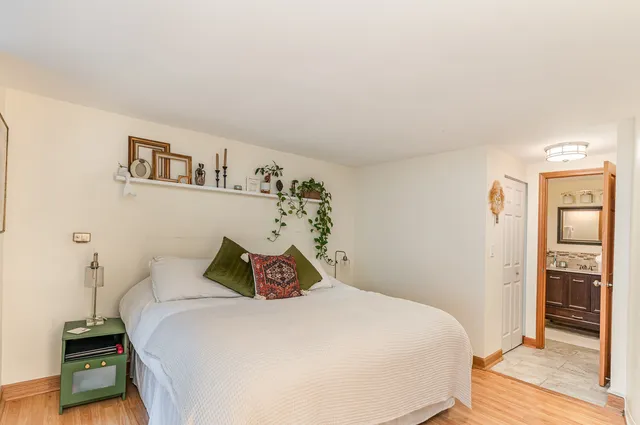 a bedroom with a bed and wooden floor