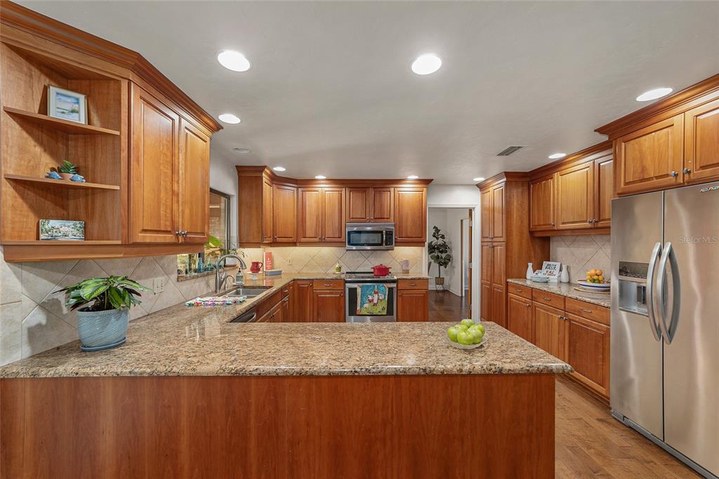 6015 Southwest 36th Way Gainesville, FL 32608 - Photo 25 of 67 a kitchen with stainless steel appliances granite countertop a sink a stove and a refrigerator