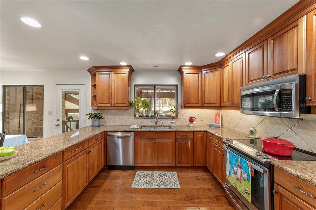 6015 Southwest 36th Way Gainesville, FL 32608 - Photo 27 of 67 a large kitchen with stainless steel appliances granite countertop a lot of counter space and a sink