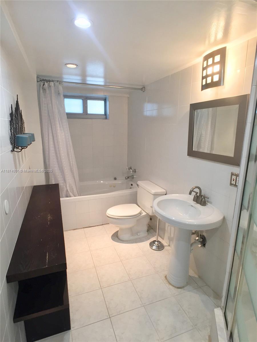 1025 Alton Road, Unit 507 Miami Beach, FL 33139 - Photo 12 of 28 a bathroom with a sink a toilet and shower