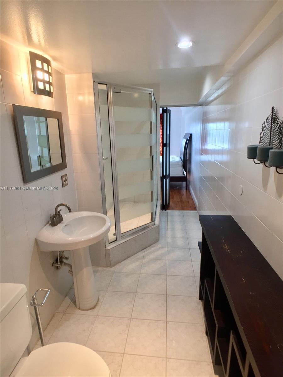1025 Alton Road, Unit 507 Miami Beach, FL 33139 - Photo 13 of 28 a bathroom with a sink a toilet and a shower