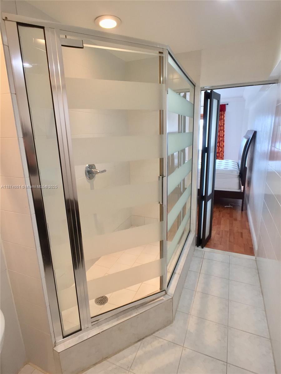 1025 Alton Road, Unit 507 Miami Beach, FL 33139 - Photo 14 of 28 a bathroom with a glass door shower and vanity
