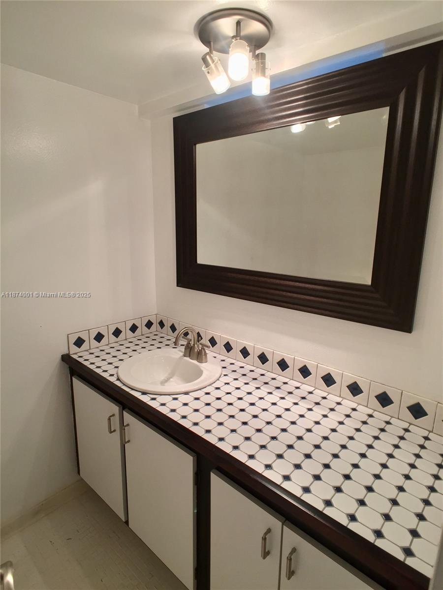 1025 Alton Road, Unit 507 Miami Beach, FL 33139 - Photo 16 of 28 a bathroom with a sink and a mirror