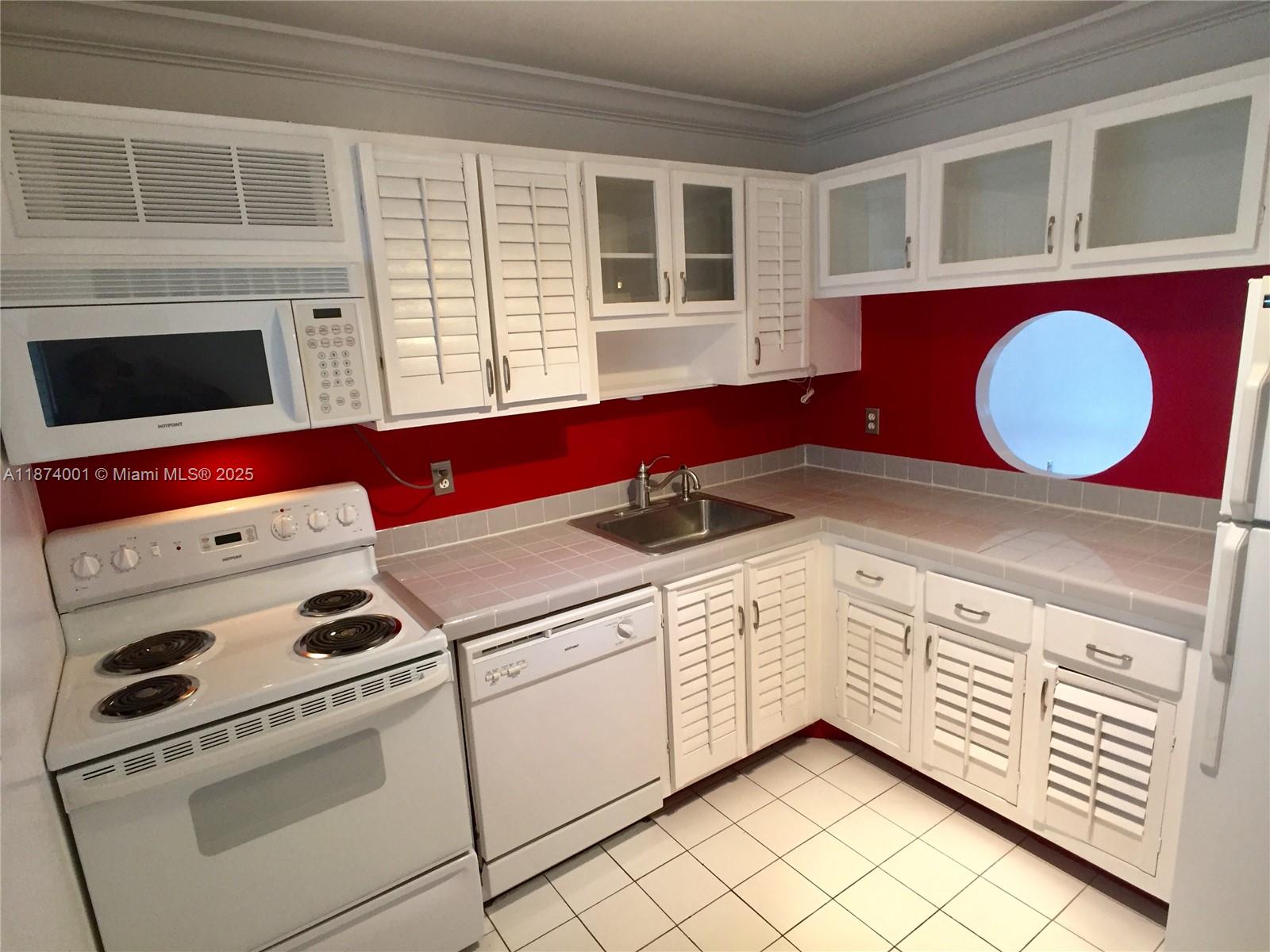 1025 Alton Road, Unit 507 Miami Beach, FL 33139 - Photo 24 of 28 a kitchen with a stove a sink and a microwave