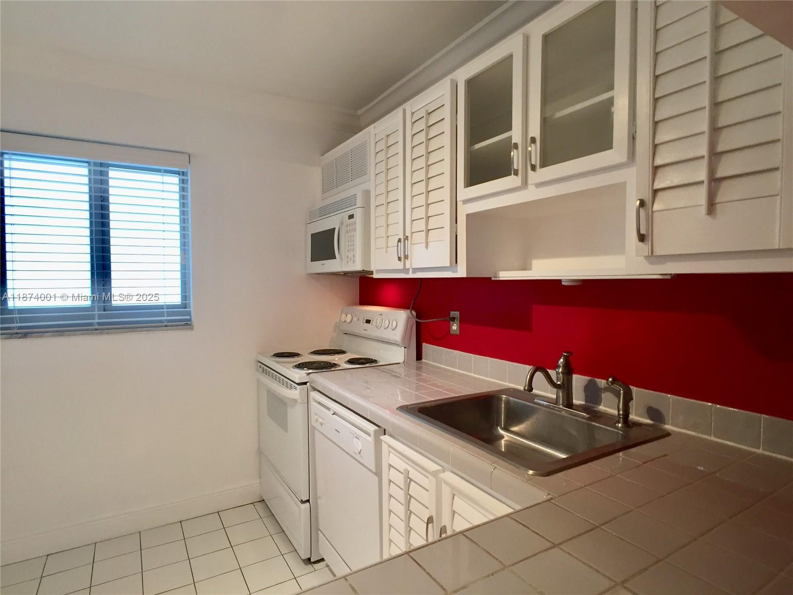 1025 Alton Road, Unit 507 Miami Beach, FL 33139 - Photo 26 of 28 a kitchen that has a sink and a stove