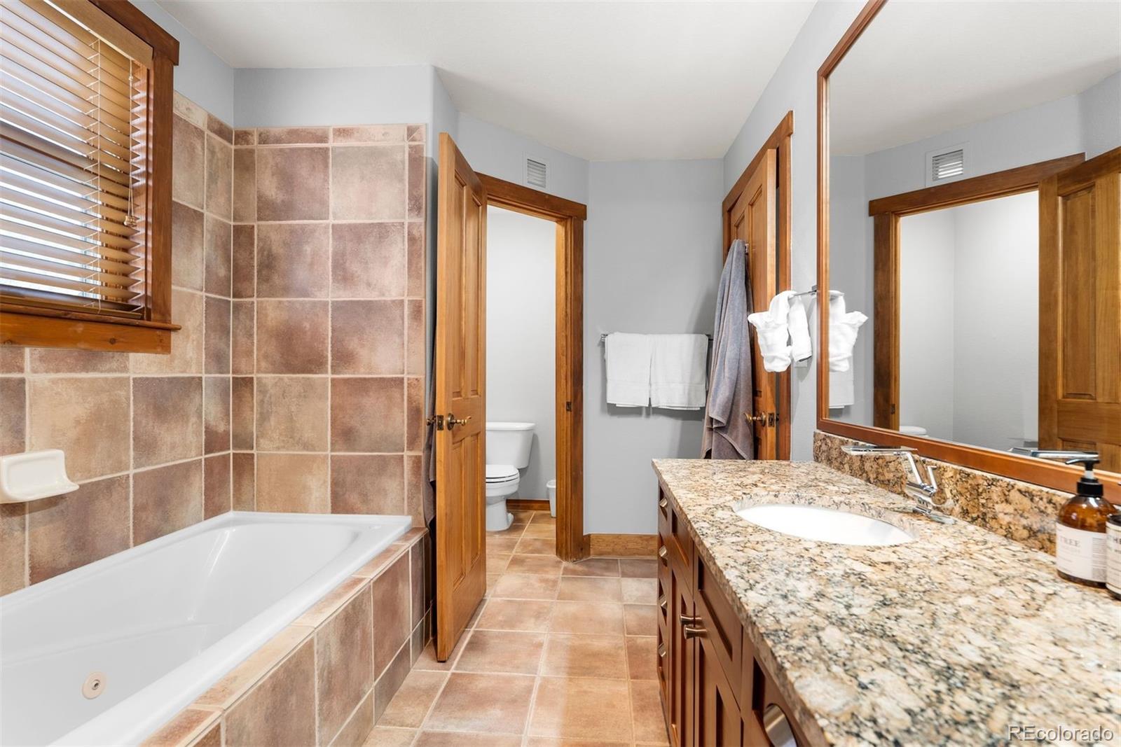88 Hawk Circle, Unit 2349 Dillon, CO 80435 - Photo 16 of 26 a bathroom with a granite countertop tub sink and mirror
