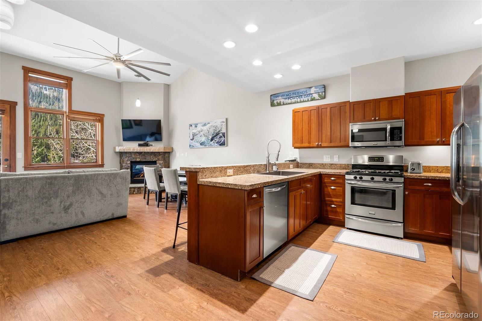 88 Hawk Circle, Unit 2349 Dillon, CO 80435 - Photo 5 of 26 a kitchen with stainless steel appliances kitchen island granite countertop a stove top oven a sink dishwasher a dining table and chairs with wooden floor