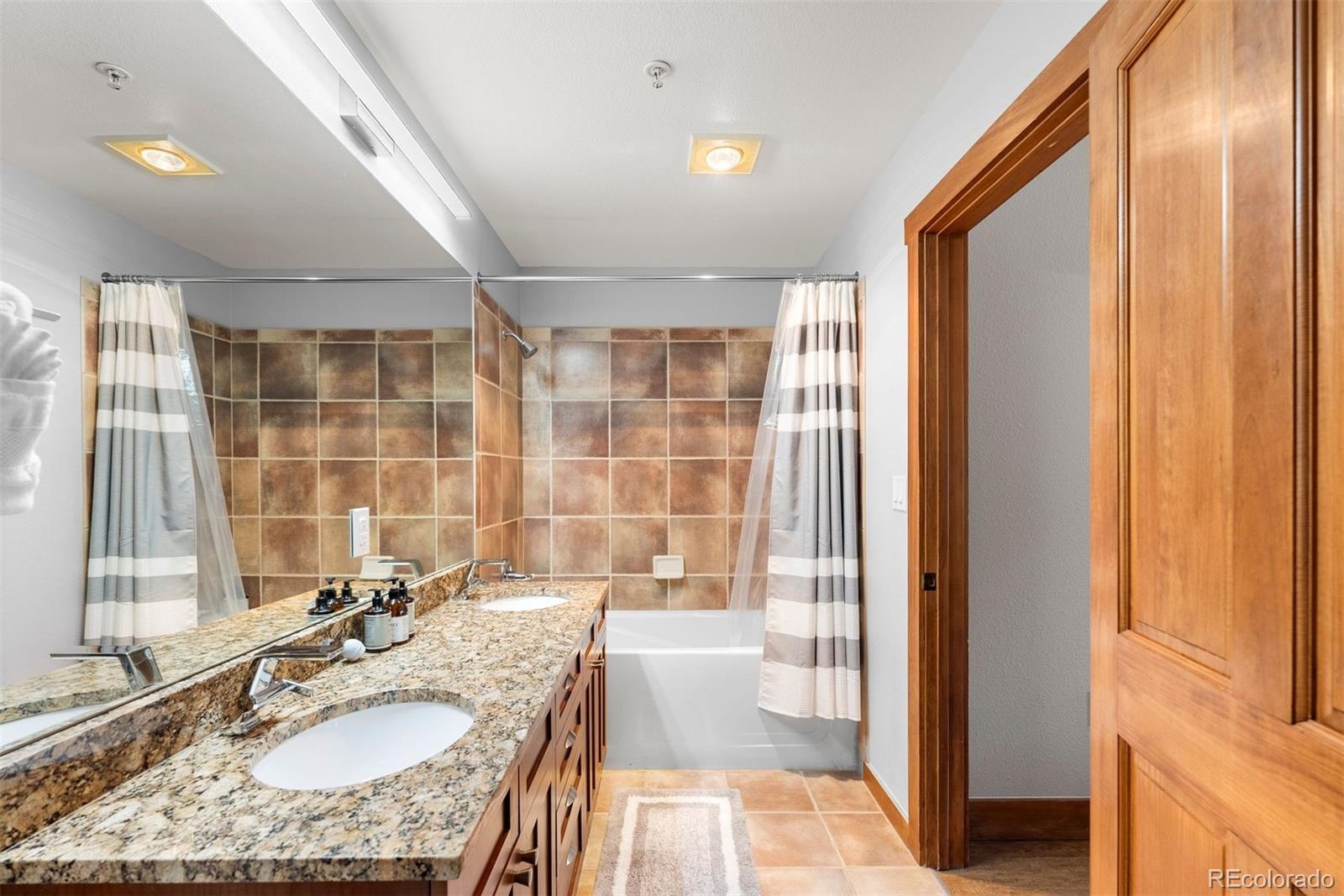 88 Hawk Circle, Unit 2349 Dillon, CO 80435 - Photo 8 of 26 a bathroom with a granite countertop sink a mirror and a bathtub