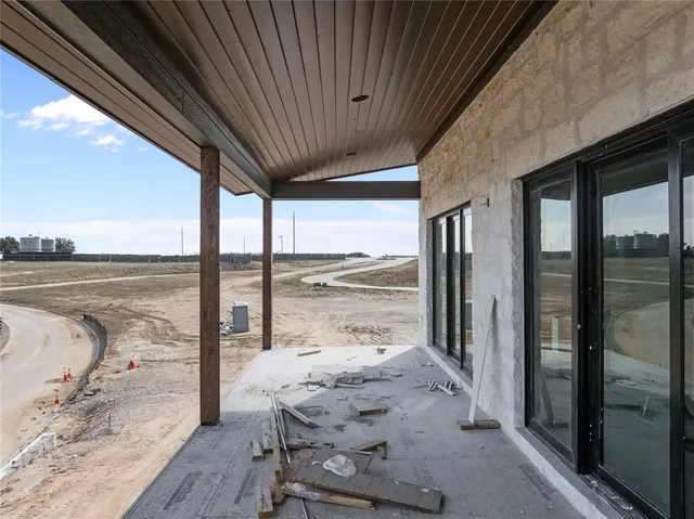 a view of swimming pool that has lawn chairs and a dining table under an umbrella