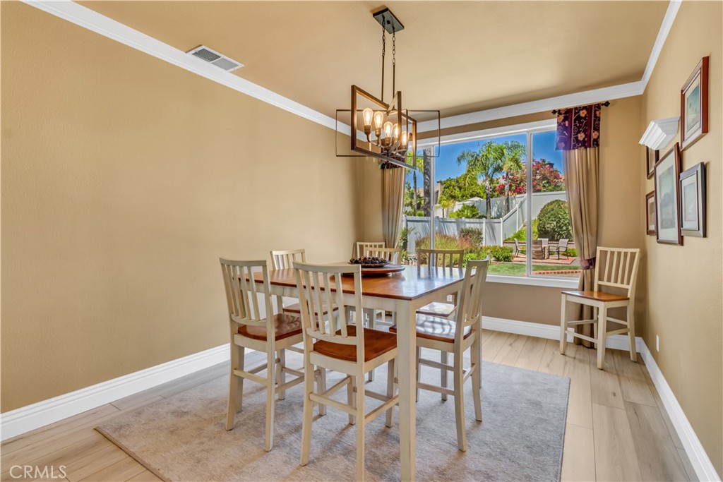 28308 Corte Ocaso Temecula, CA 92592 - Photo 13 of 43 a view of a dining room with furniture a chandelier and wooden floor
