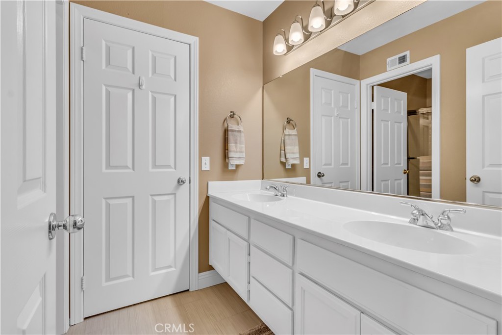 28308 Corte Ocaso Temecula, CA 92592 - Photo 30 of 43 a bathroom with a double vanity sink and a mirror