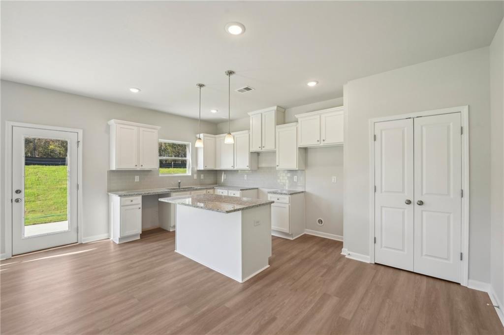 11124 Suria Drive Covington, GA 30014 - Photo 12 of 31 a kitchen with a white stove cabinets and wooden floor