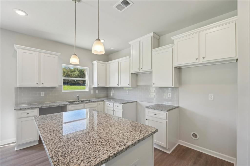 11124 Suria Drive Covington, GA 30014 - Photo 14 of 31 a kitchen with a white center island and cabinets
