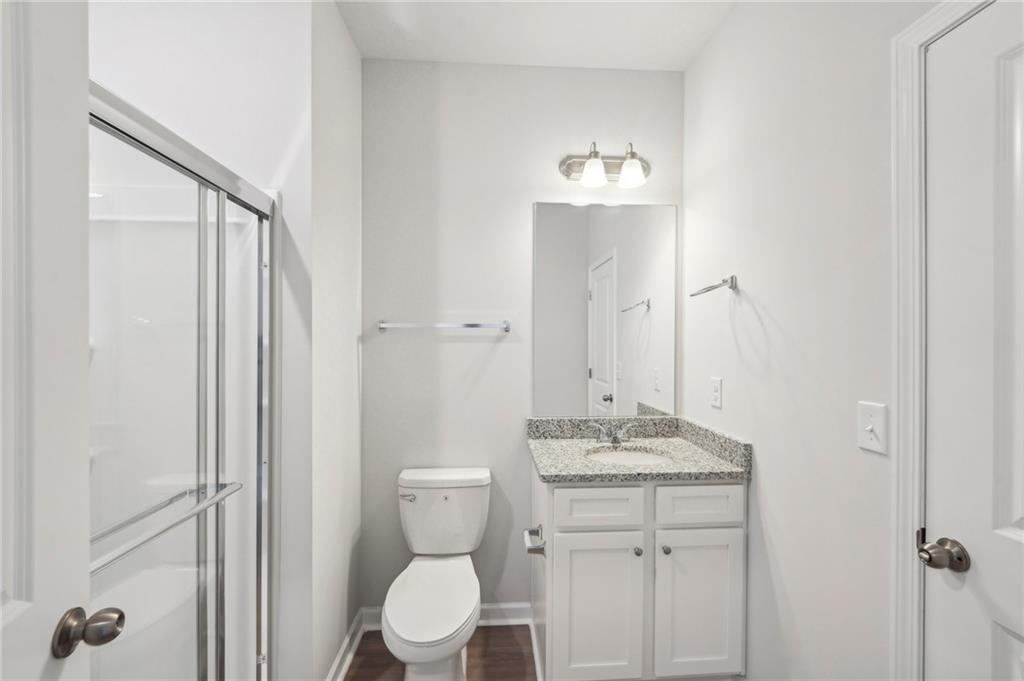 11124 Suria Drive Covington, GA 30014 - Photo 21 of 31 a bathroom with a granite countertop sink toilet and shower