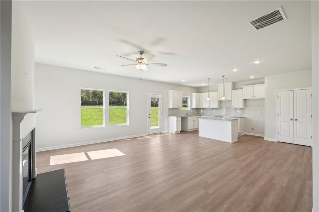 11124 Suria Drive Covington, GA 30014 - Photo 4 of 31 a view of an empty room with a window and wooden floor