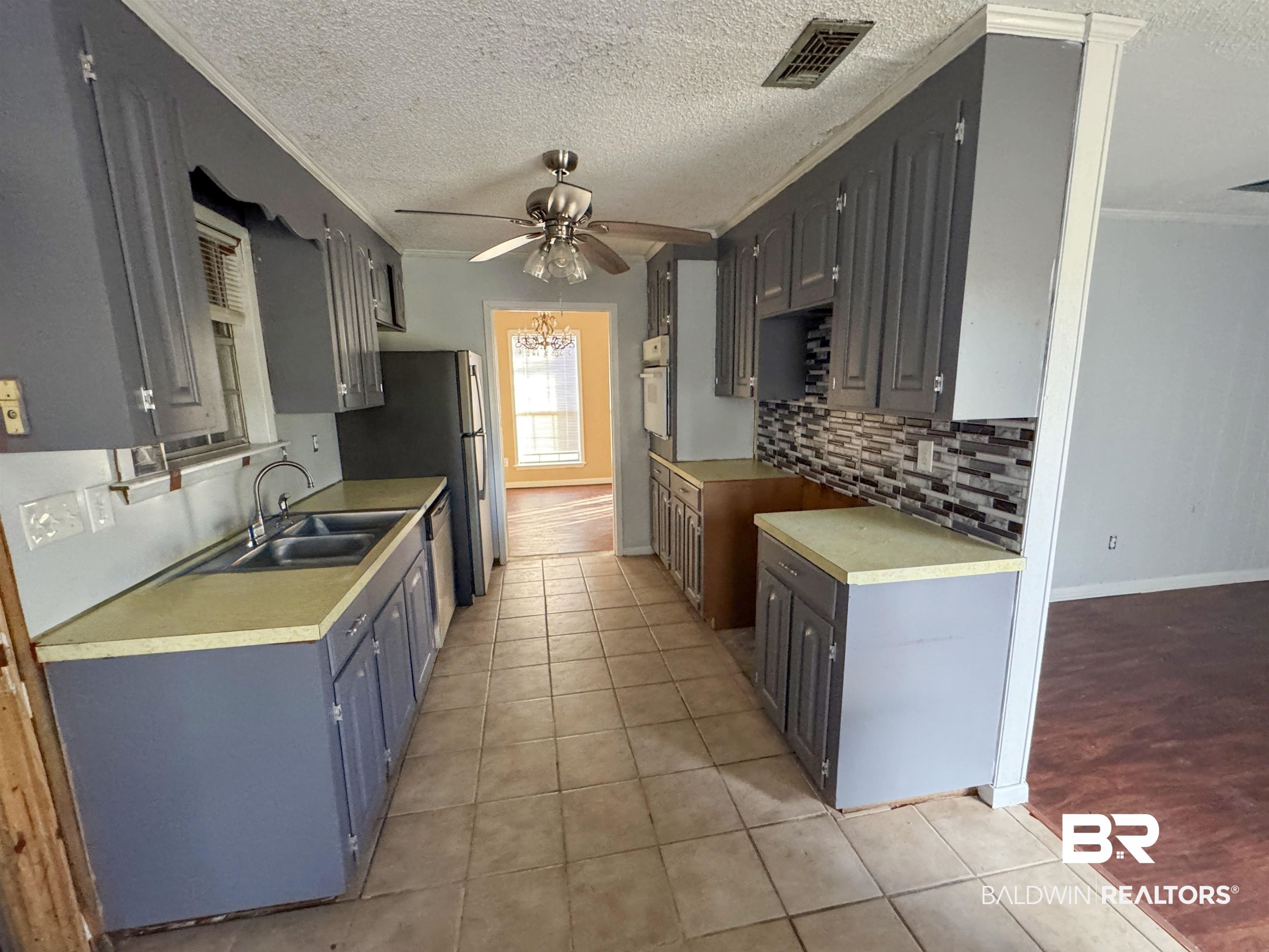 1227 Northgate Drive Atmore, AL 36502 - Photo 3 of 14 Kitchen featuring a textured ceiling, light tile patterned floors, light countertops, a ceiling fan, and gray cabinetry