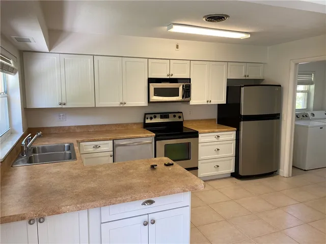 a kitchen with refrigerator and microwave
