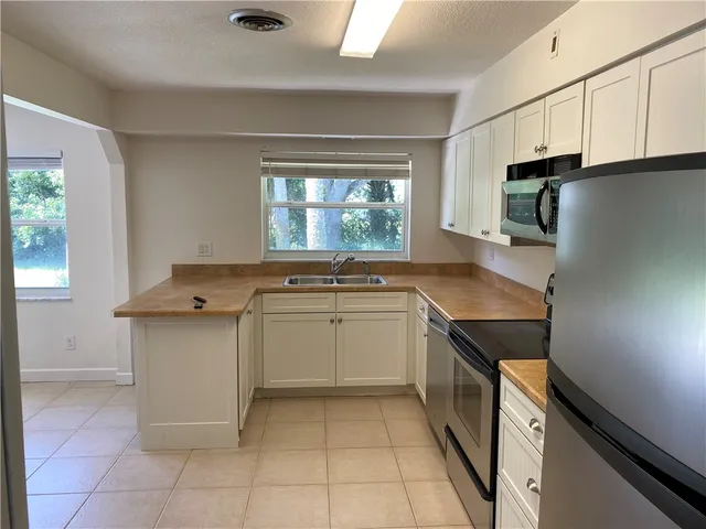 a kitchen with refrigerator and microwave