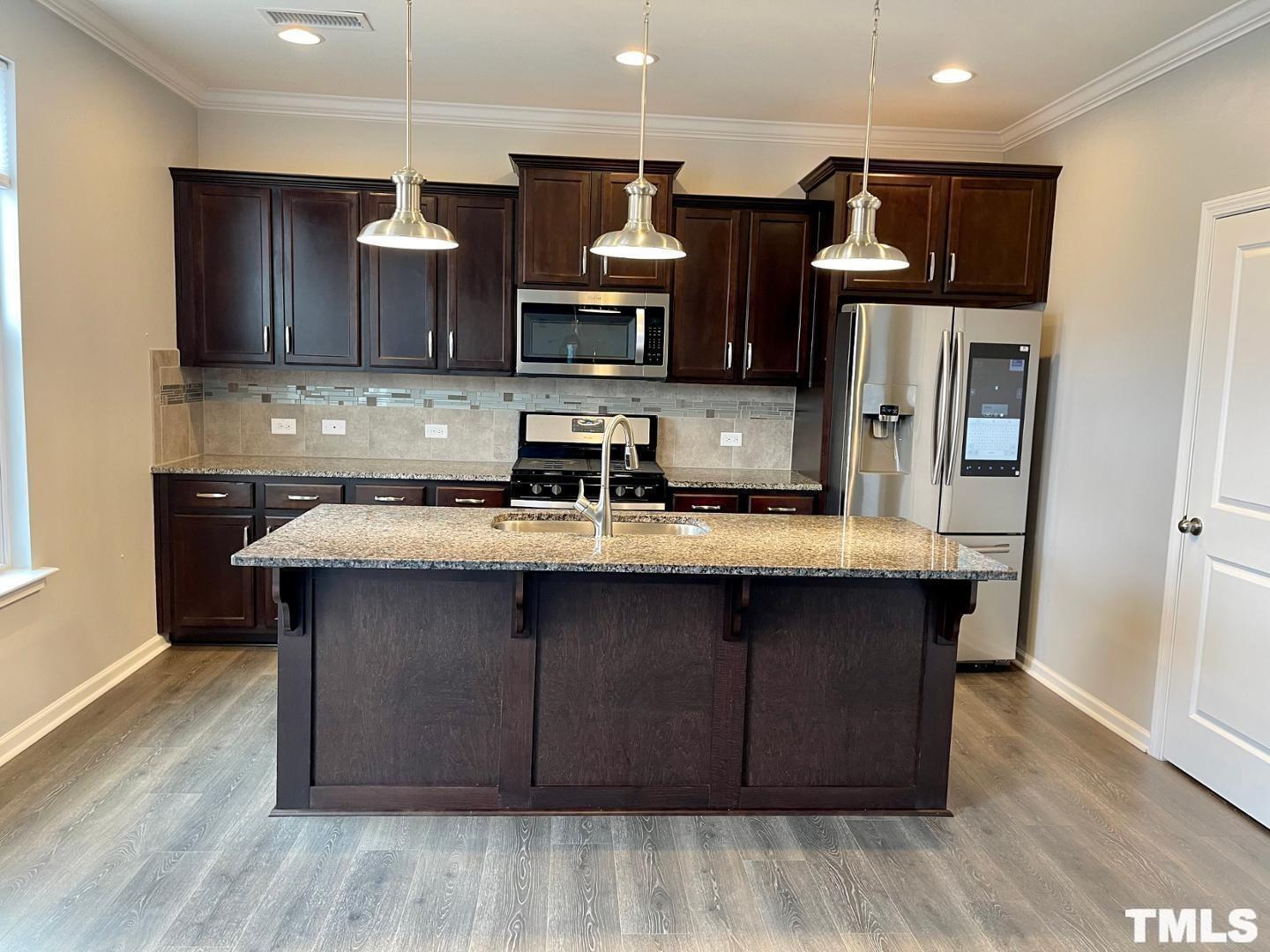 343 Great Northern Station Apex, NC 27502 - Photo 11 of 29 a kitchen with stainless steel appliances granite countertop a sink stove and refrigerator