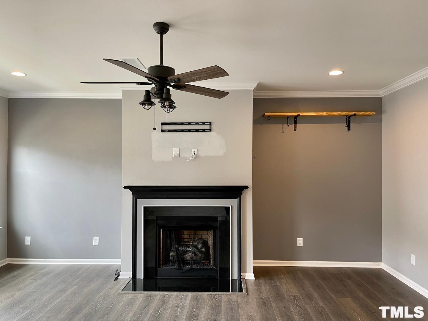 343 Great Northern Station Apex, NC 27502 - Photo 6 of 29 a view of a livingroom with a fireplace a chandelier fan and wooden floor