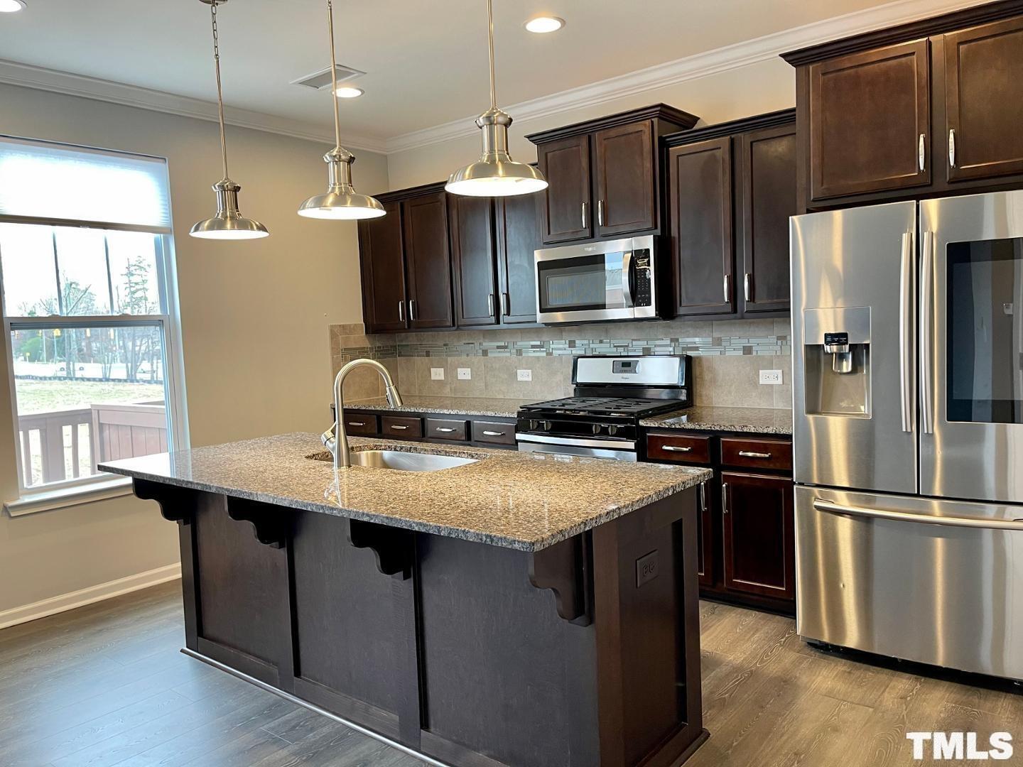 343 Great Northern Station Apex, NC 27502 - Photo 10 of 29 a kitchen with stainless steel appliances granite countertop a sink refrigerator and microwave