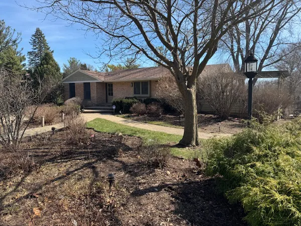 a front view of a house with yard and green space