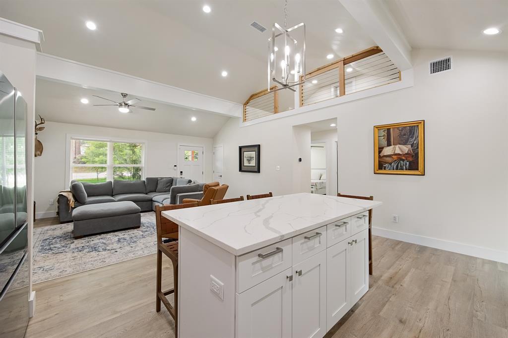 114 Ricky Road Gun Barrel City, TX 75156 - Photo 11 of 18 Kitchen island featuring a veined countertop, white cabinetry with silver hardware, and integrated seating