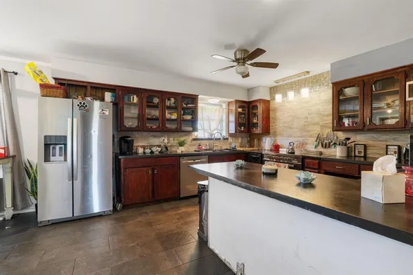 a kitchen with stainless steel appliances granite countertop a refrigerator a sink and a stove