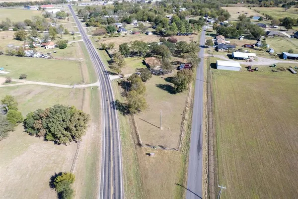 an aerial view of a house with a yard and lake view in back