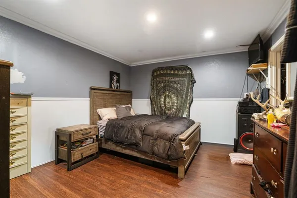 a bedroom with a bed and wooden floor