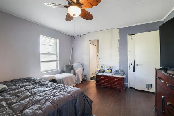 a bedroom with a bed and a chandelier fan