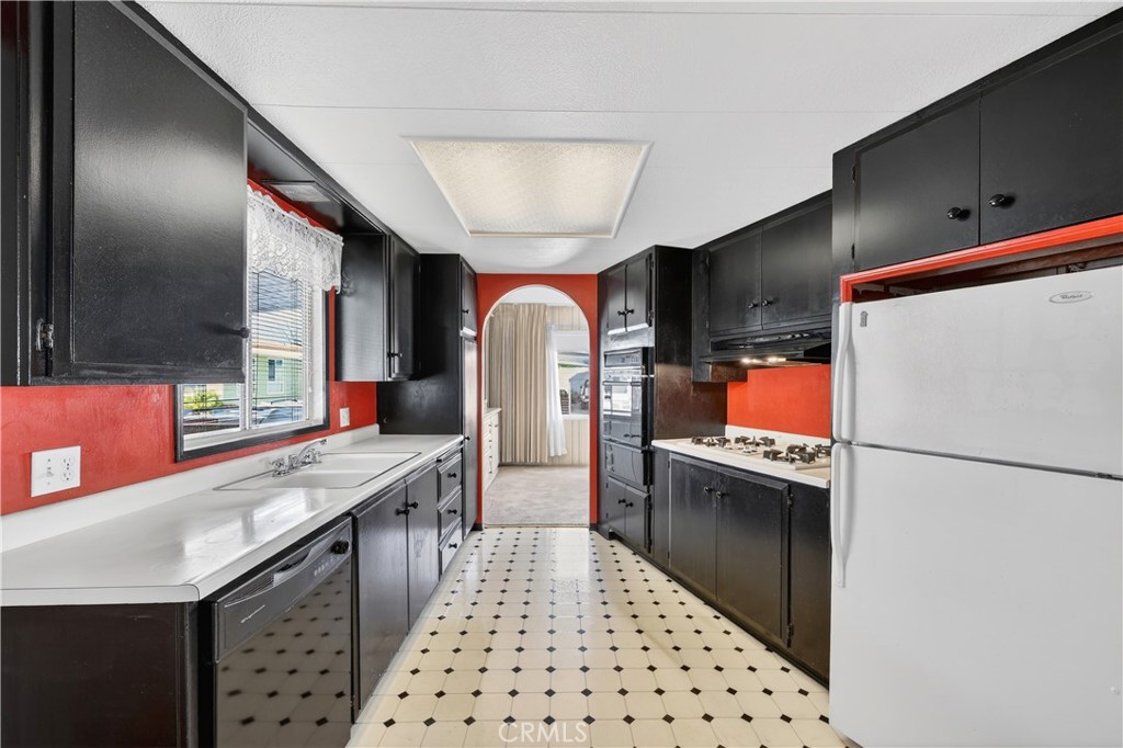1001 East Lambert Road, Unit 258 La Habra, CA 90631 - Photo 13 of 75 a kitchen with stainless steel appliances a refrigerator a sink and wooden cabinets