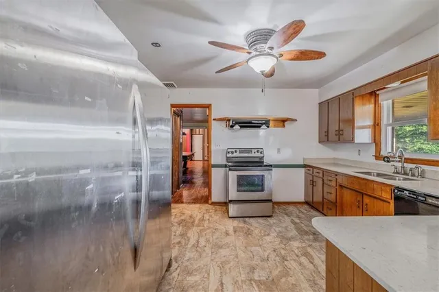 a large kitchen with stainless steel appliances kitchen island granite countertop a sink and a stove