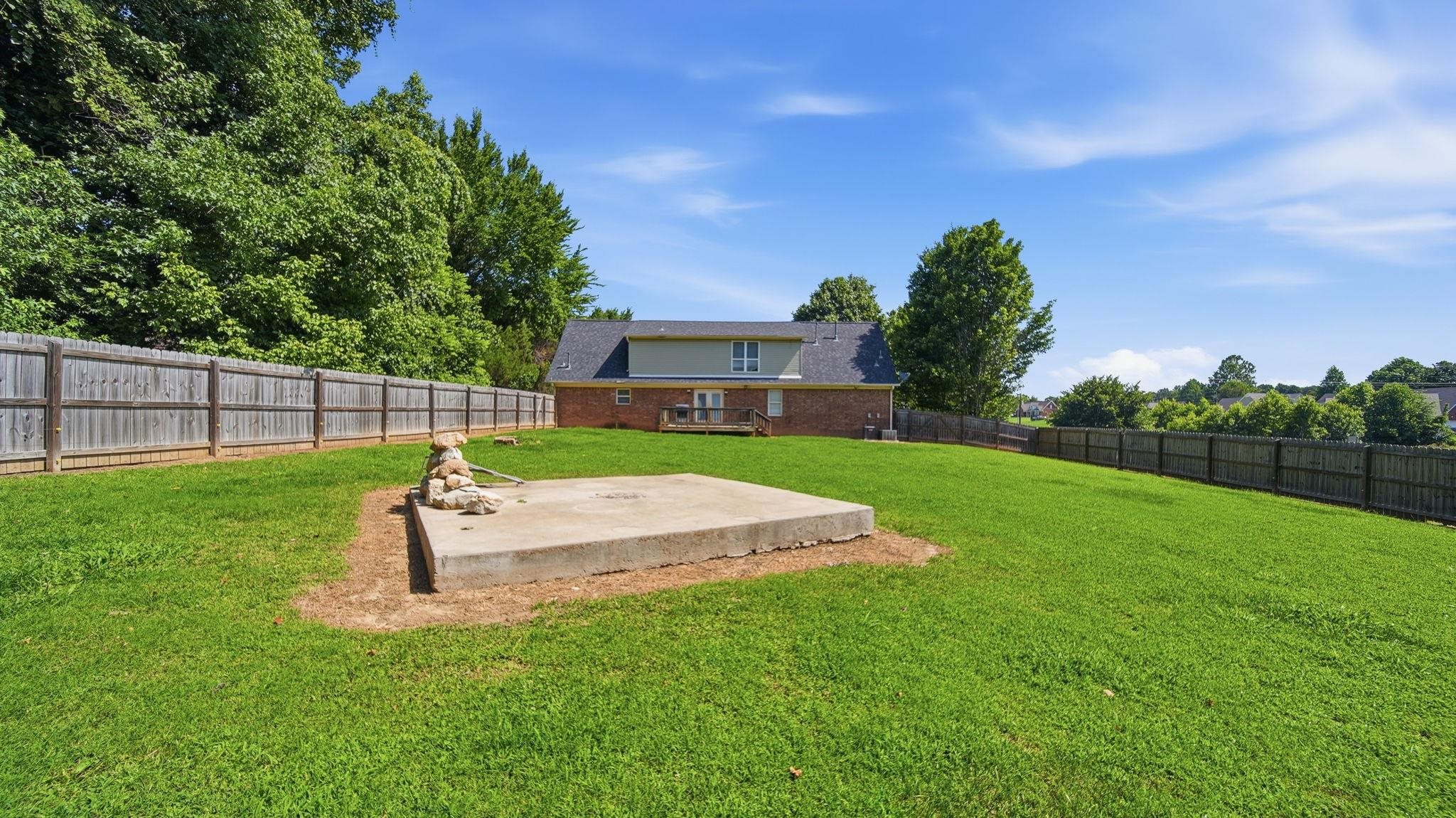 217 Rae Drive Munford, TN 38058 - Photo 36 of 40 Expansive green lawn with a privacy fence bordering the property