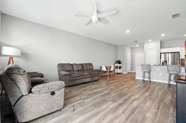 a living room with furniture and a wooden floor
