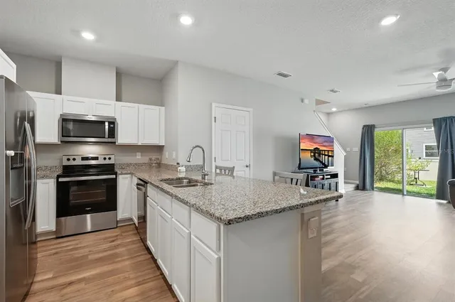 a kitchen with sink a microwave and cabinets