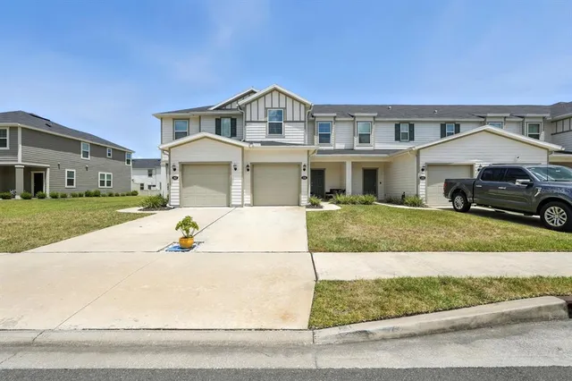 a view of a white house with a big yard and large trees