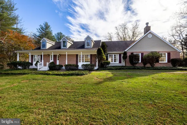 a front view of a house with a garden and trees