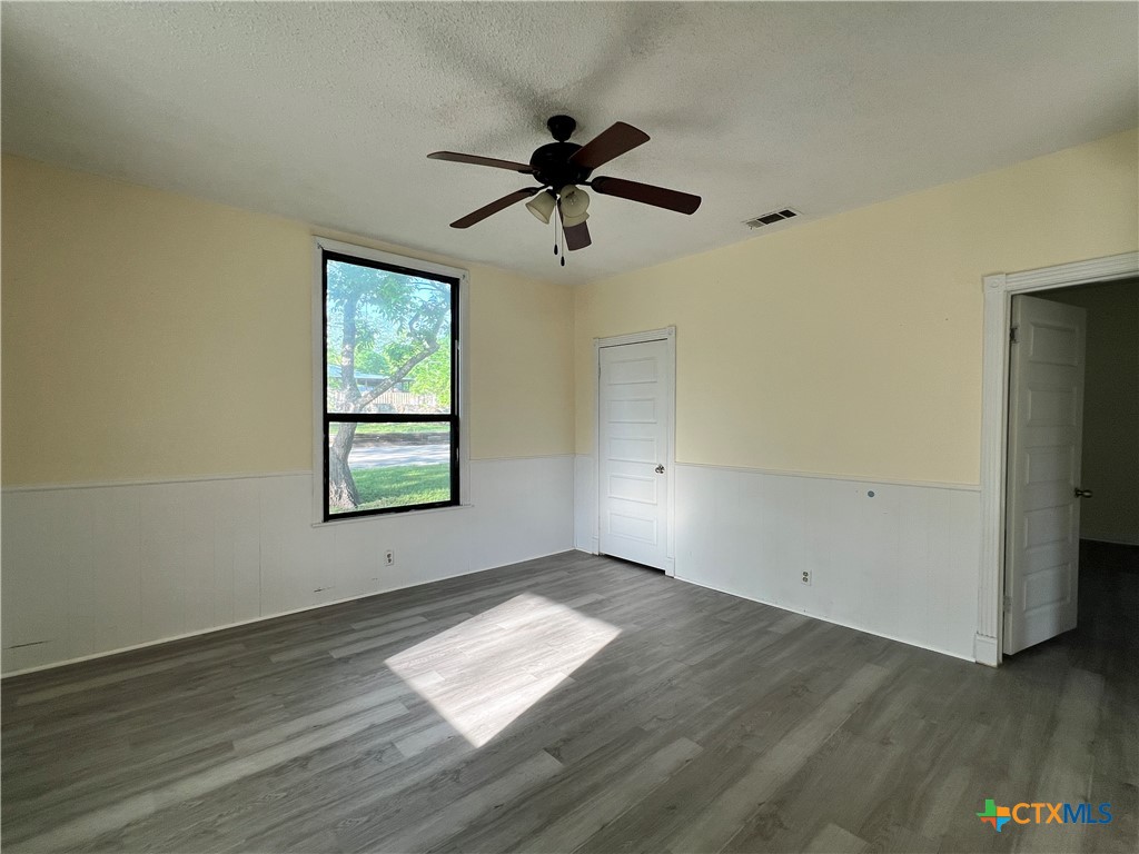 902 North 1st Street Temple, TX 76501 - Photo 22 of 29 an empty room with wooden floor fan and windows