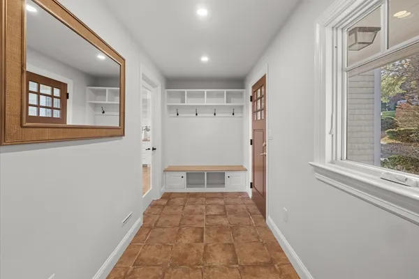 a view of a hallway with wooden floor and a window