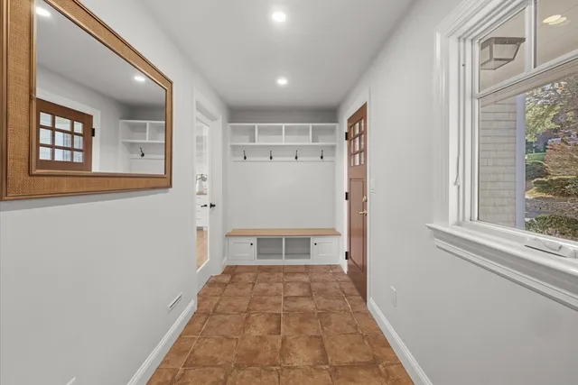 a view of a hallway with wooden floor and a window