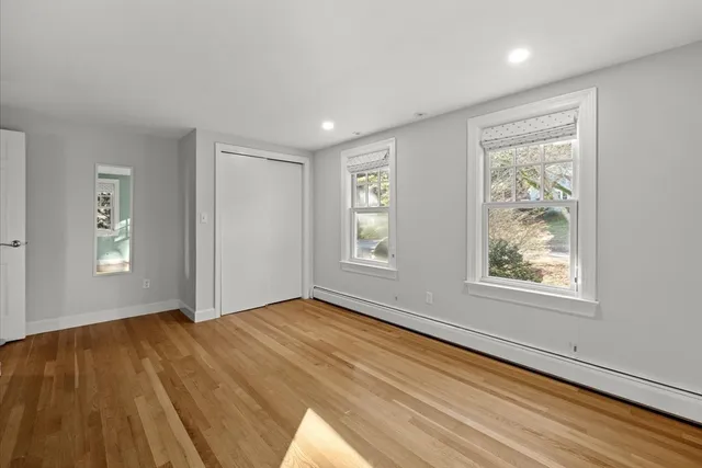 a view of an empty room window and wooden floor