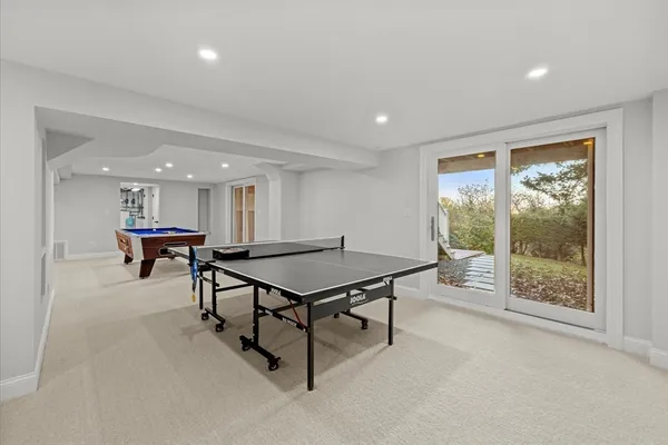 a room with furniture pool table and wooden floor