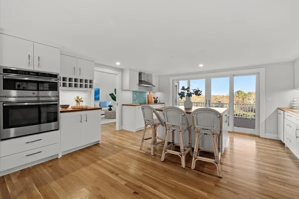 a kitchen with stainless steel appliances a table chairs and a refrigerator