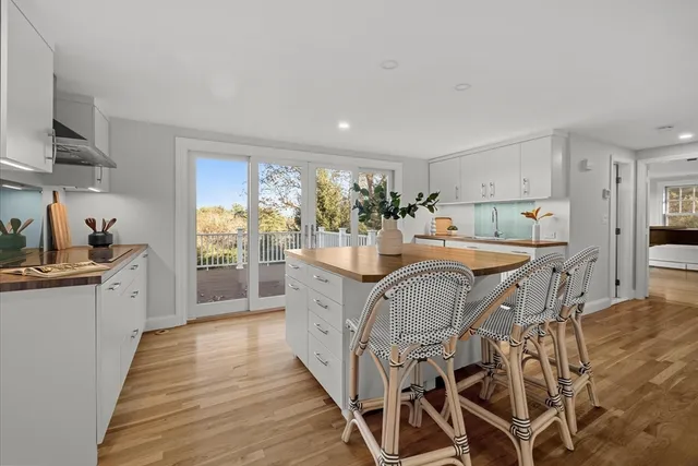 a kitchen with granite countertop lots of wooden cabinets a sink a stove and a refrigerator