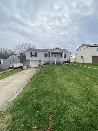 a view of a house with a big yard and large trees